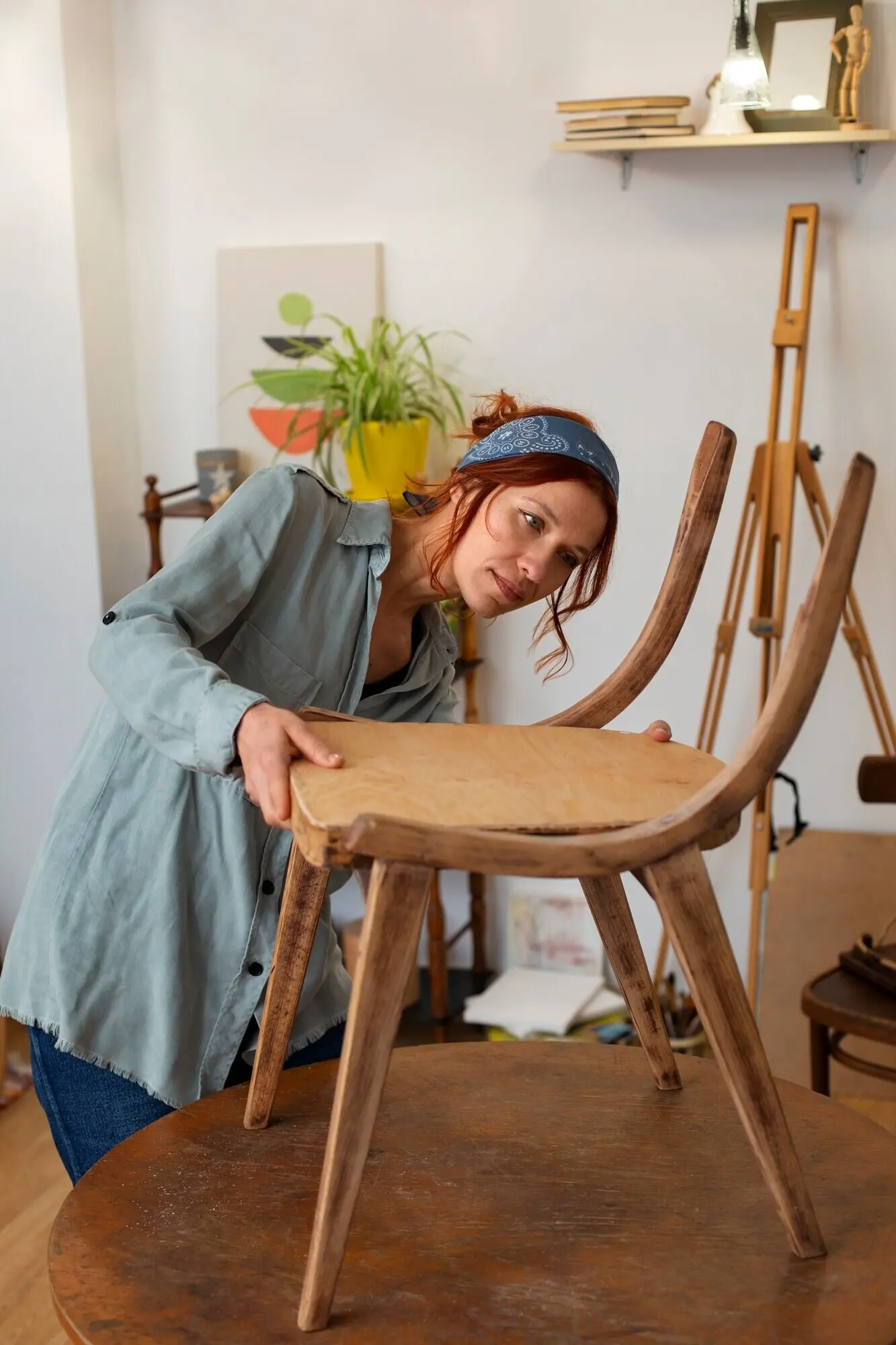 Halbtotale einer Frau, die Möbel restauriert.