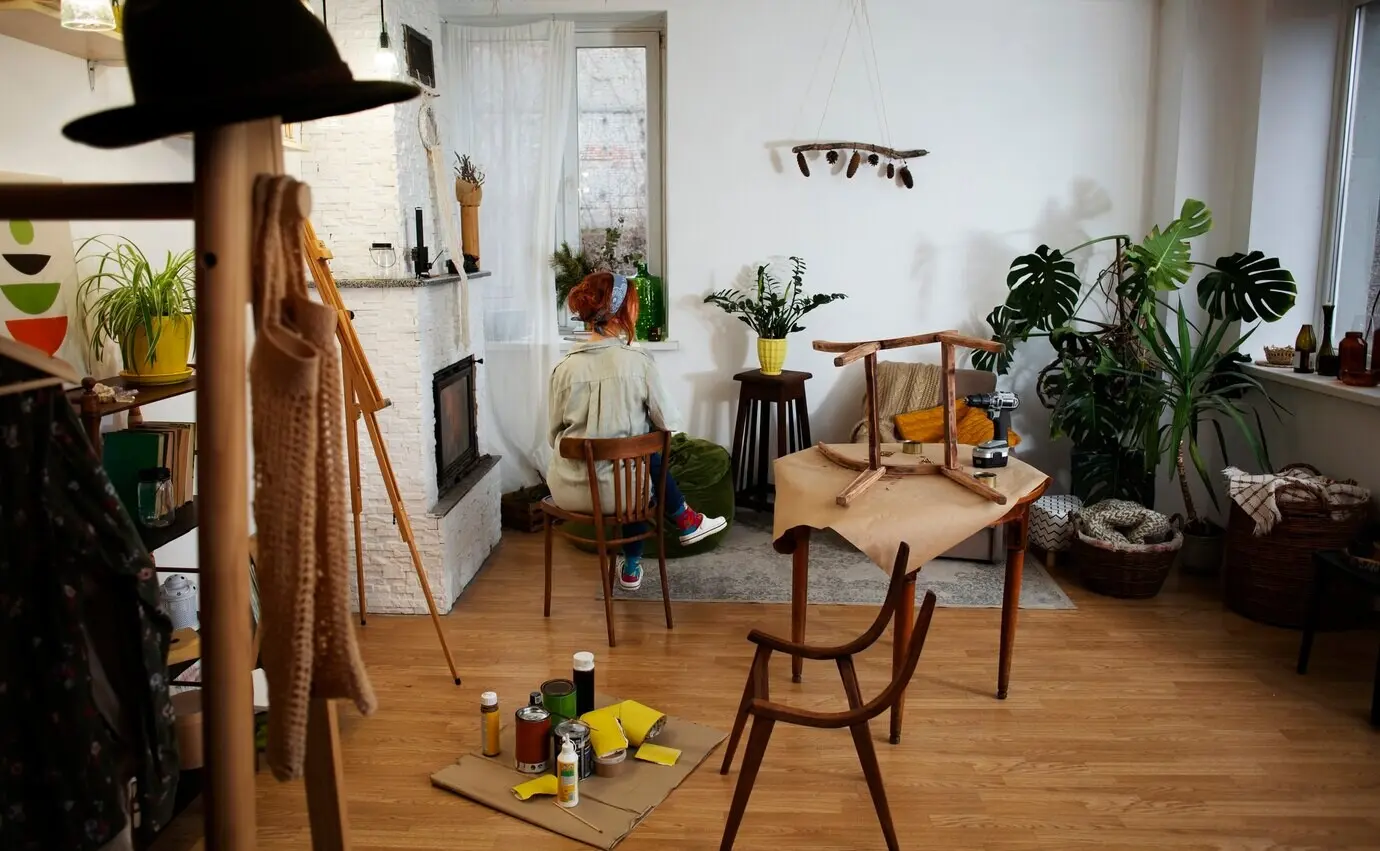 Ganzkörperaufnahme einer Frau, die Möbel restauriert.